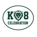 An oval white magnet with a dark green border and text reading 'K 8 CELEBRATION', featuring a green lion head emblem between the letters.